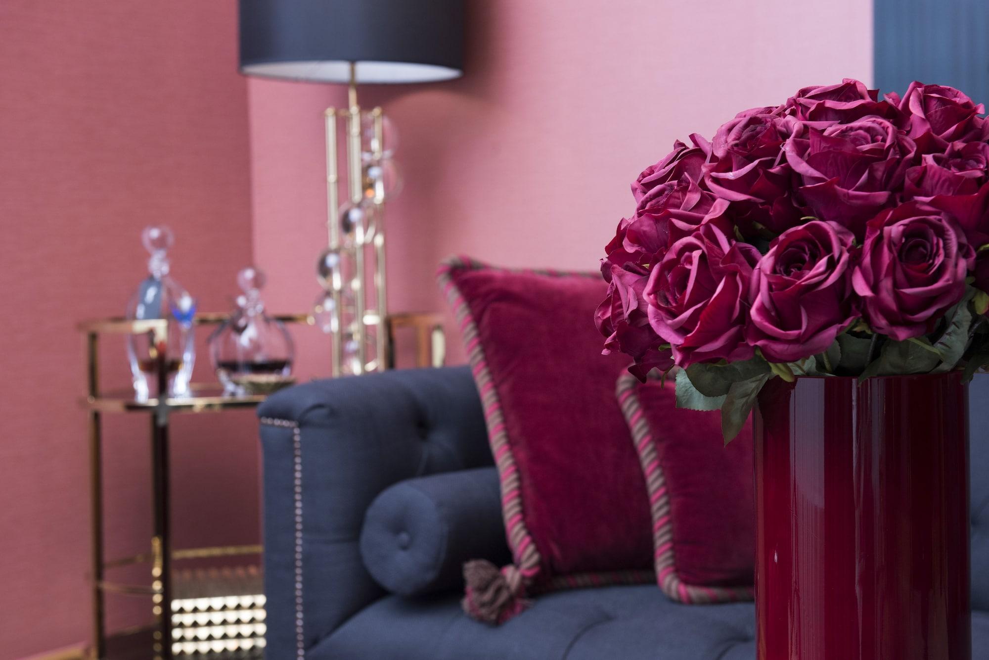 Hotel Palace Berlín Exterior foto A living room with a dark blue sofa and a red vase